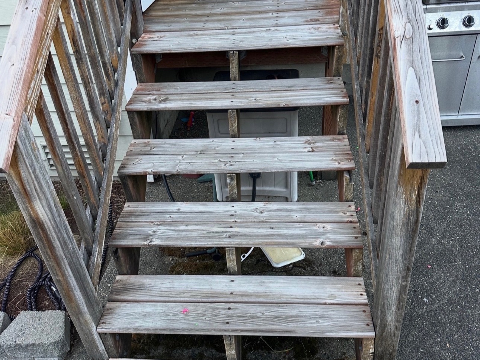 Before: Weathered wood entry stairs replaced with composite treads and black aluminum railing