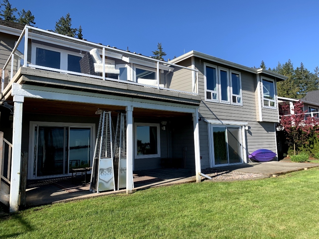 Two-story home with a new upper composite deck and a covered patio underneath