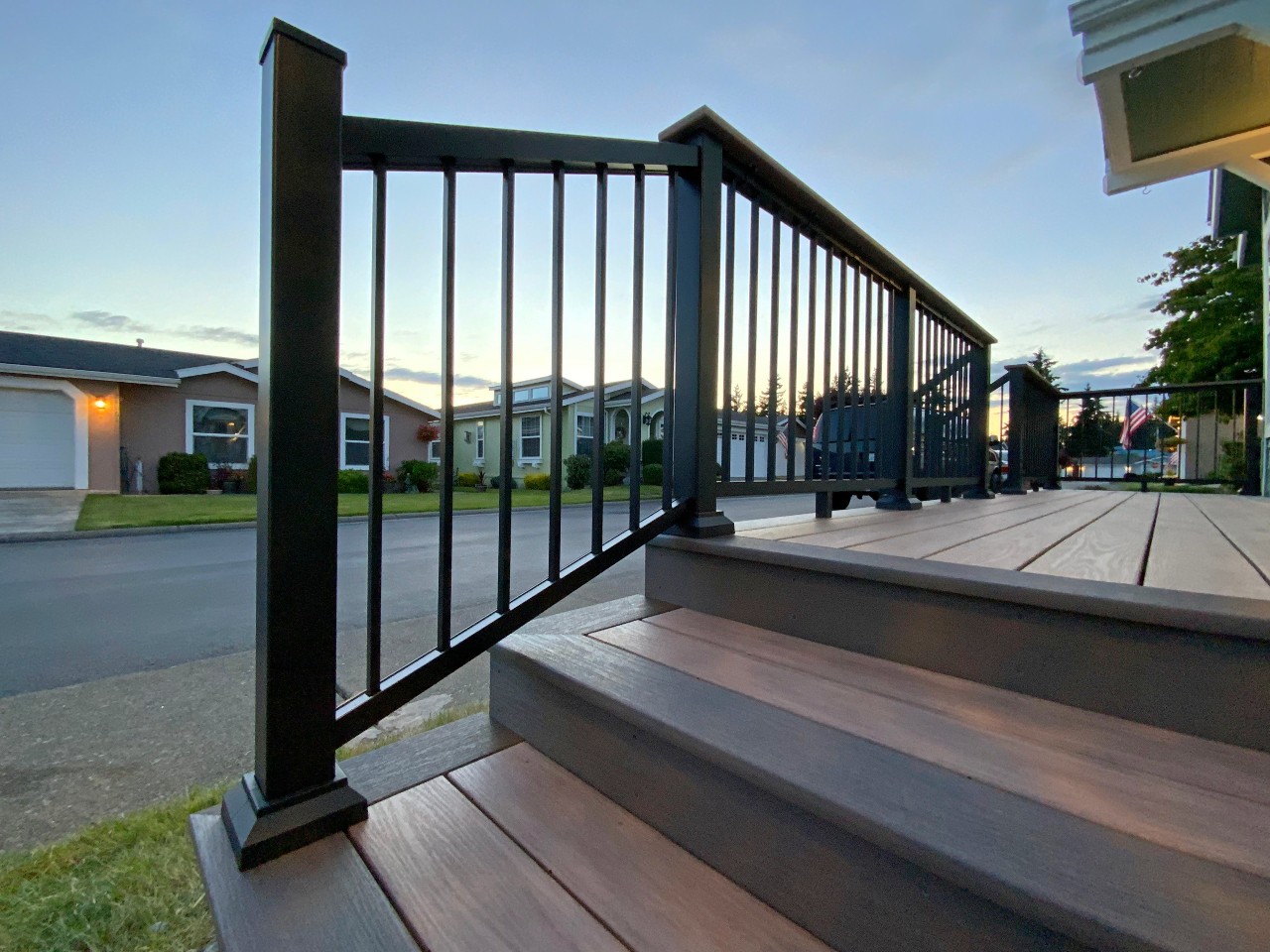 Composite stairs with black aluminum railing at sunset