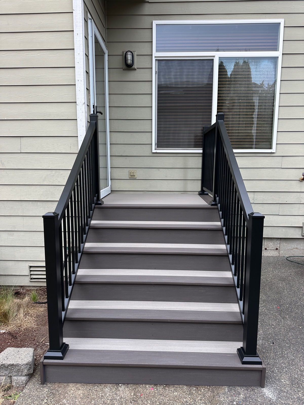Composite entry stairs with black railing viewed straight on