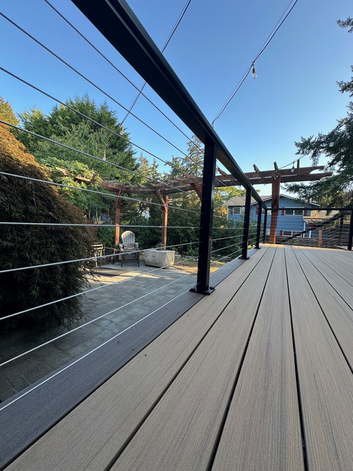 Cable railing and composite decking under a cedar pergola