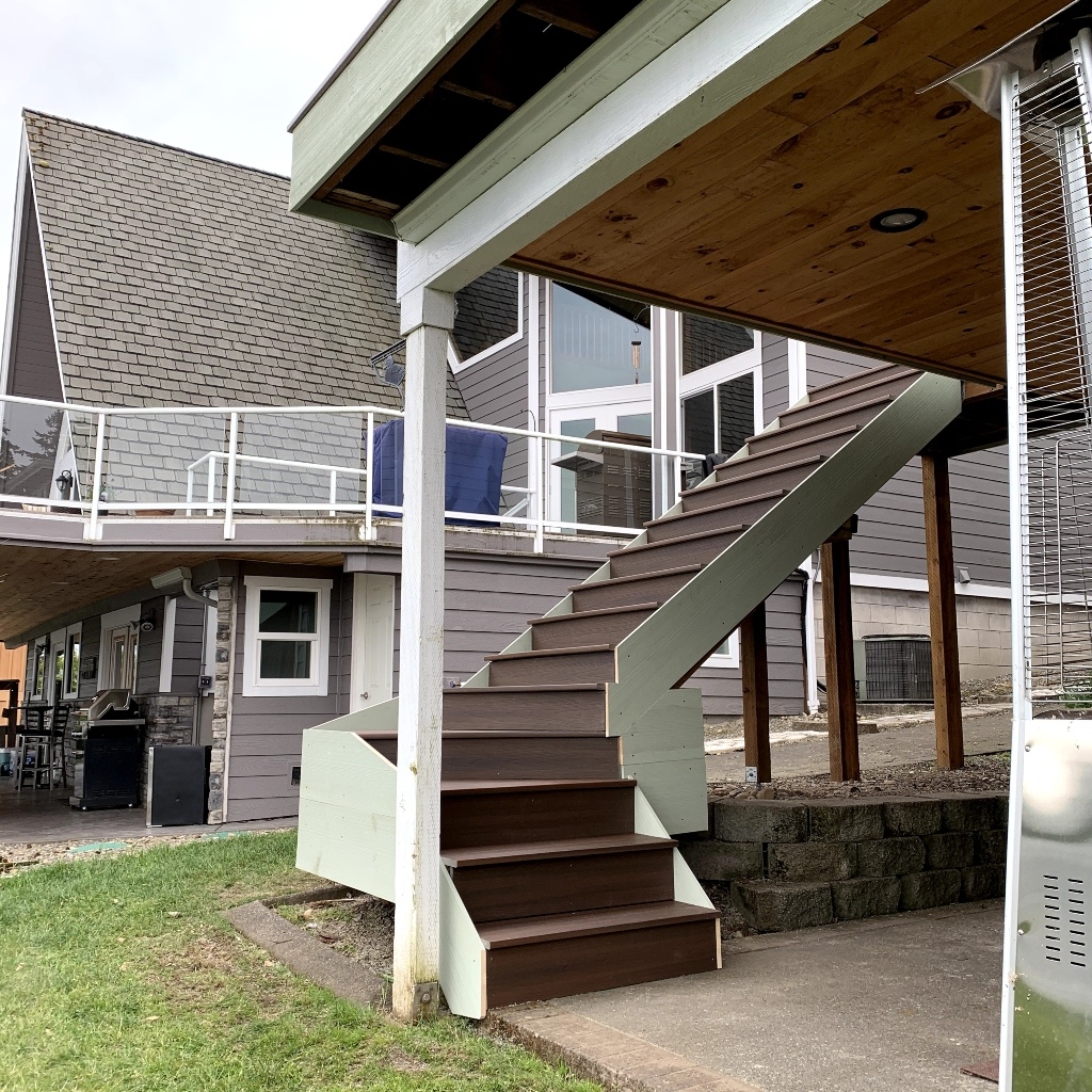 Wraparound deck with white railing and a new stair run down to the patio
