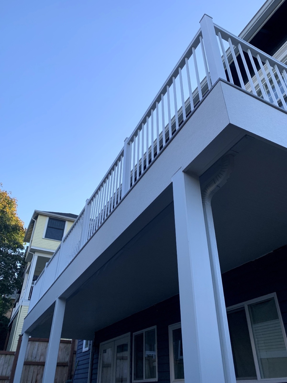 Underside of an elevated deck showing the white beams and posts