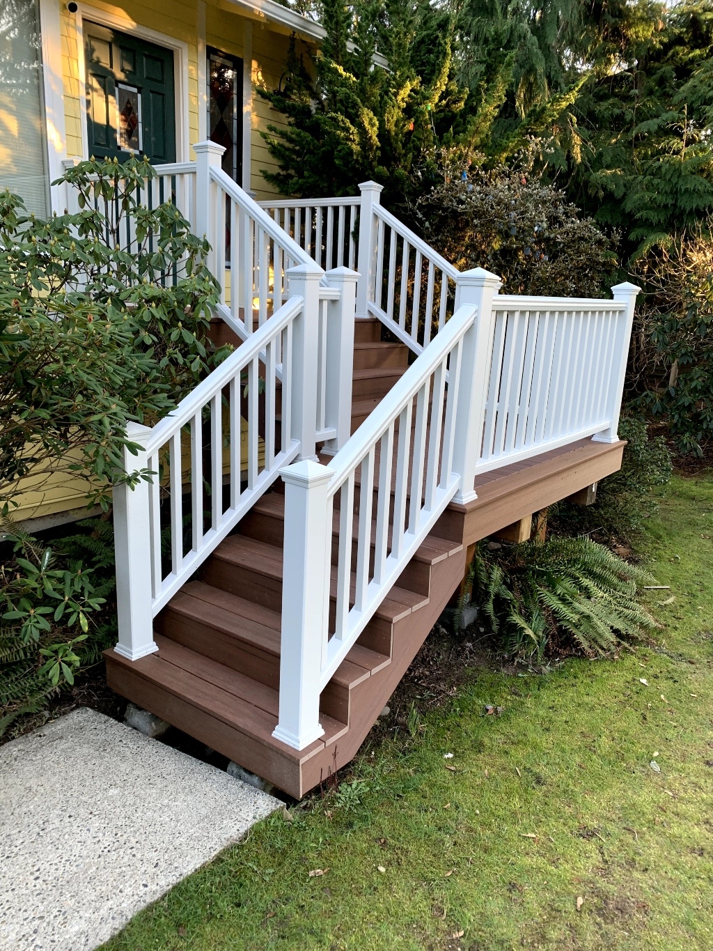 Composite stairs with white railing on a wooded lot