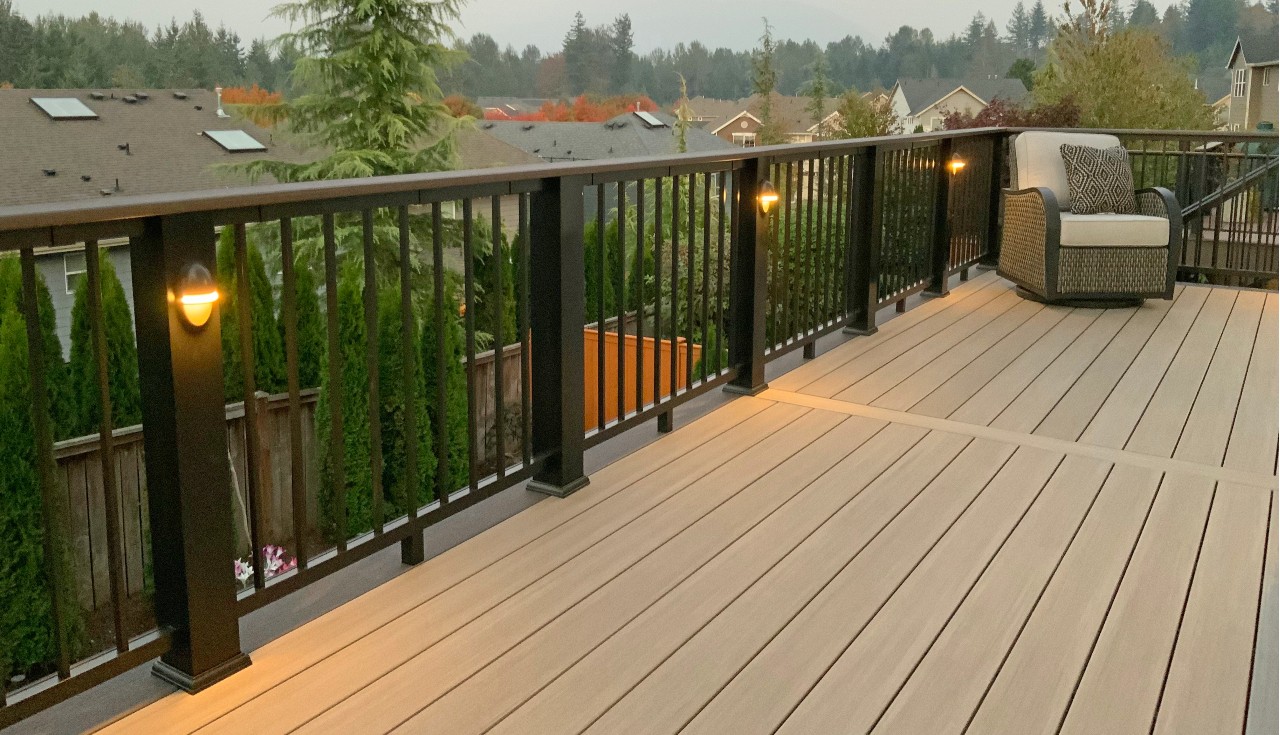 Composite deck with black railing and post-cap lighting at dusk