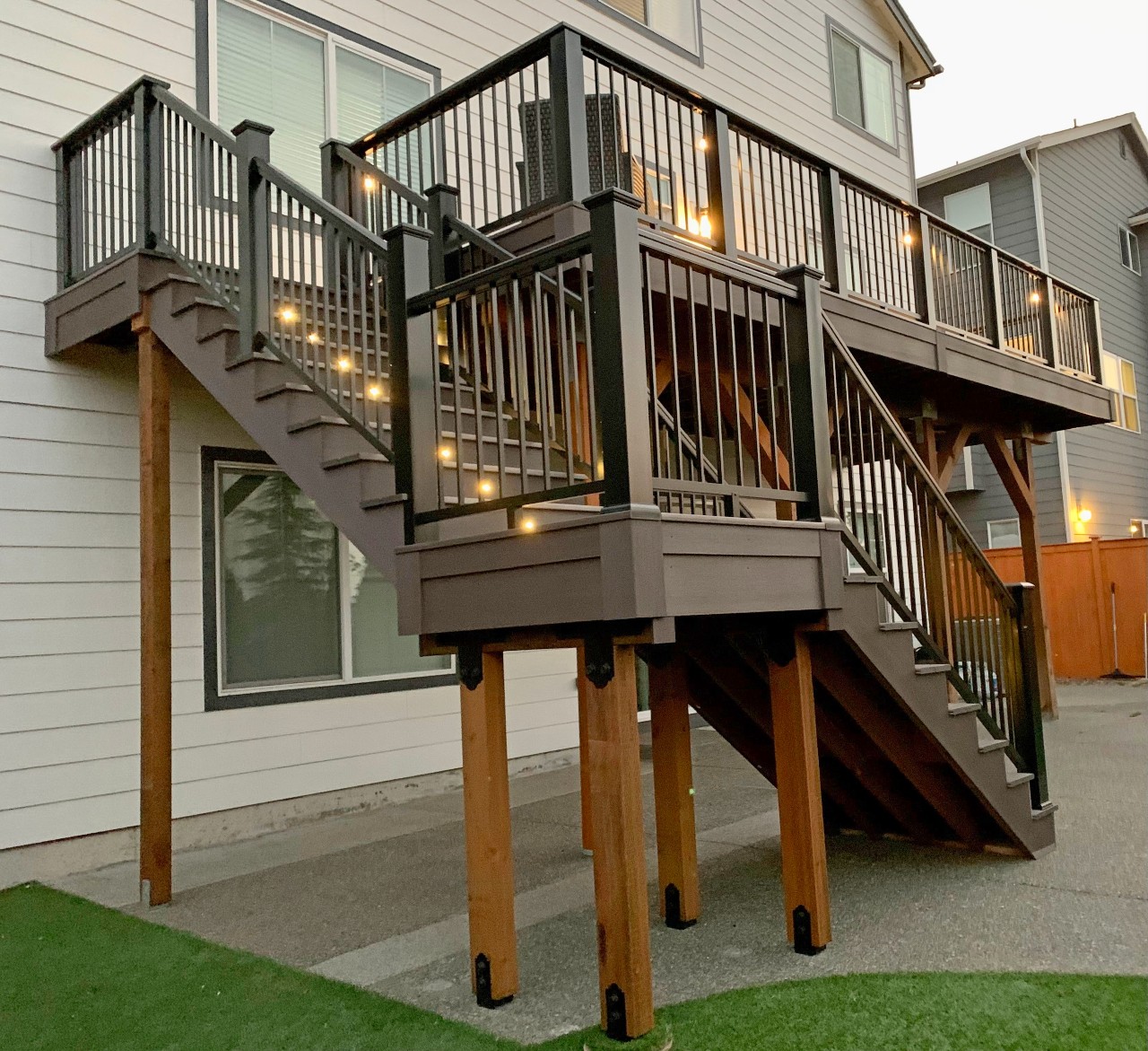 Elevated composite deck with stairs and lighting at dusk