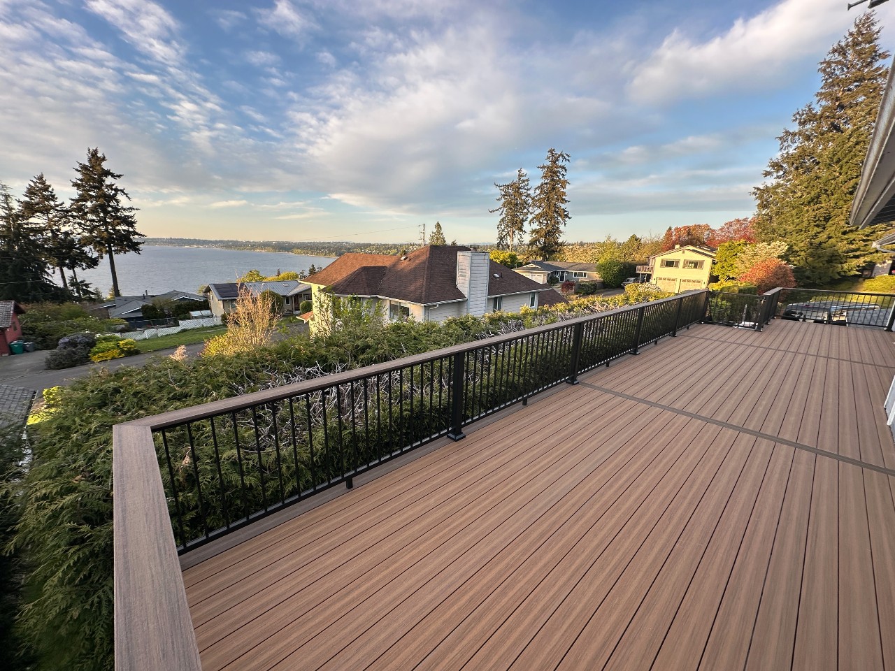 Composite deck with black aluminum railing in autumn at sunset