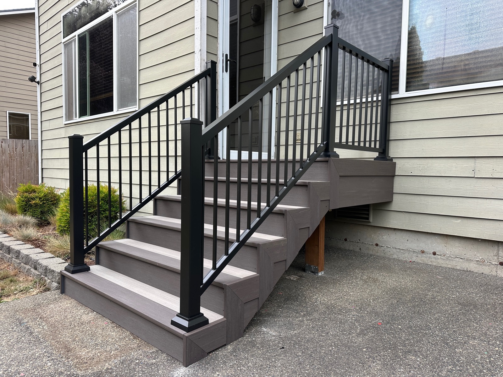 Side view of new composite entry stairs with black railing