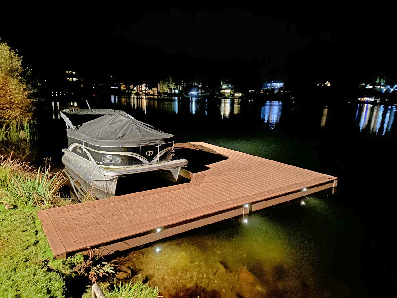 Composite dock and boat lift lit at night