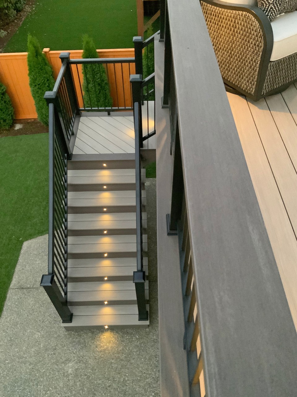Composite stair treads with riser lighting and black railing