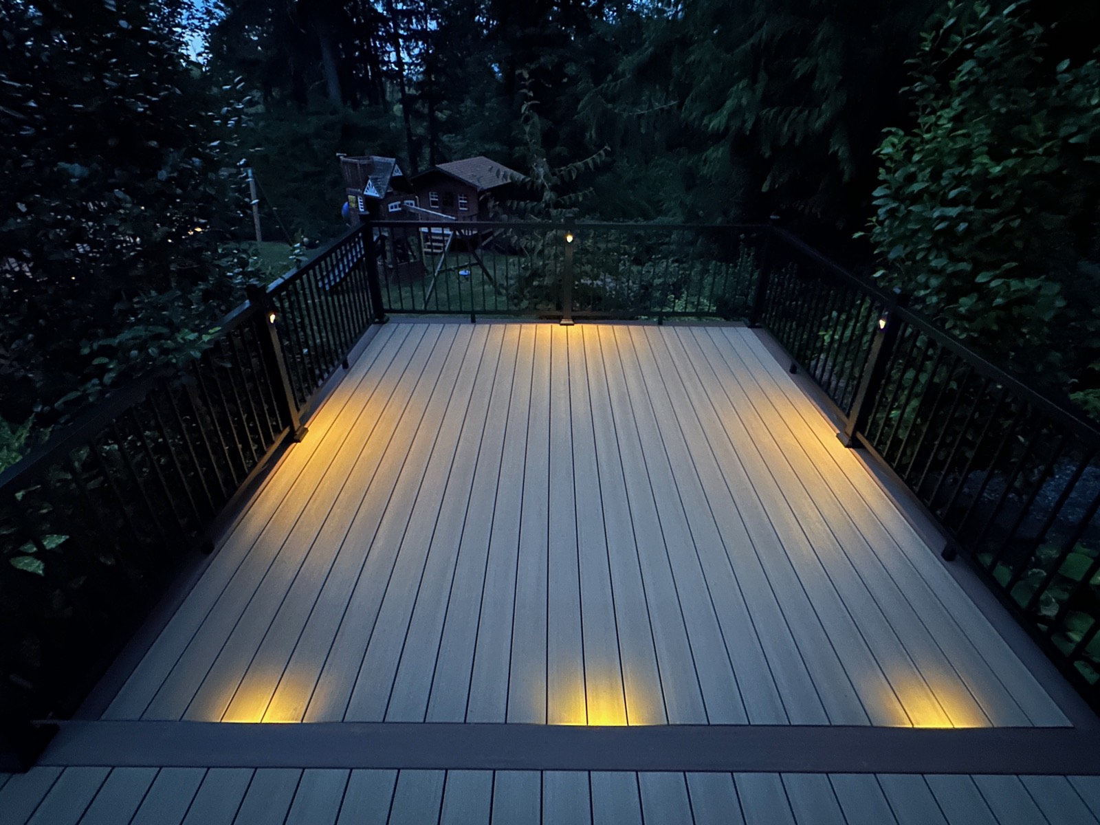 Composite deck glowing with low-voltage lighting after dark