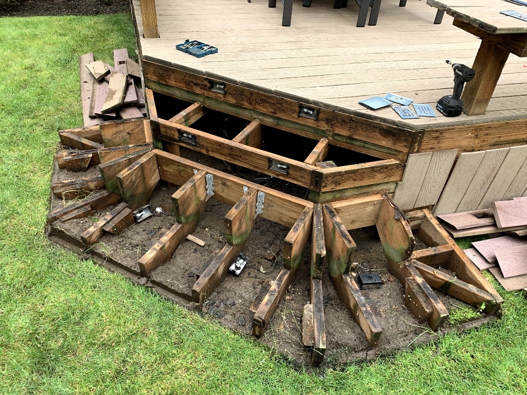 Old deck torn down to its rotted joists before a full rebuild