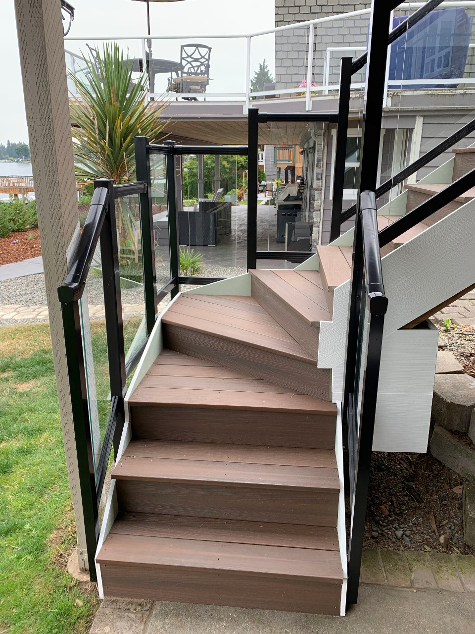 Composite stairs with glass-panel railing down to the patio