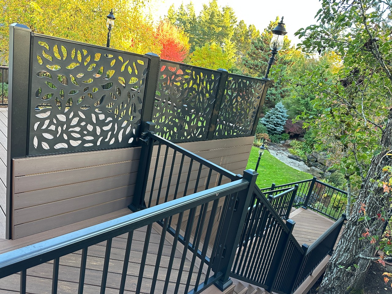 Laser-cut privacy screen panel on a cedar deck with black railing
