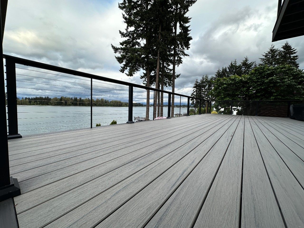 Grey composite lakefront deck with cable railing