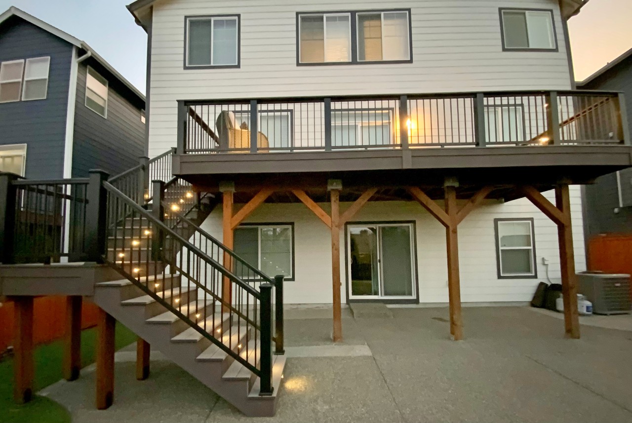 Elevated composite deck on timber support posts with stairs to the patio