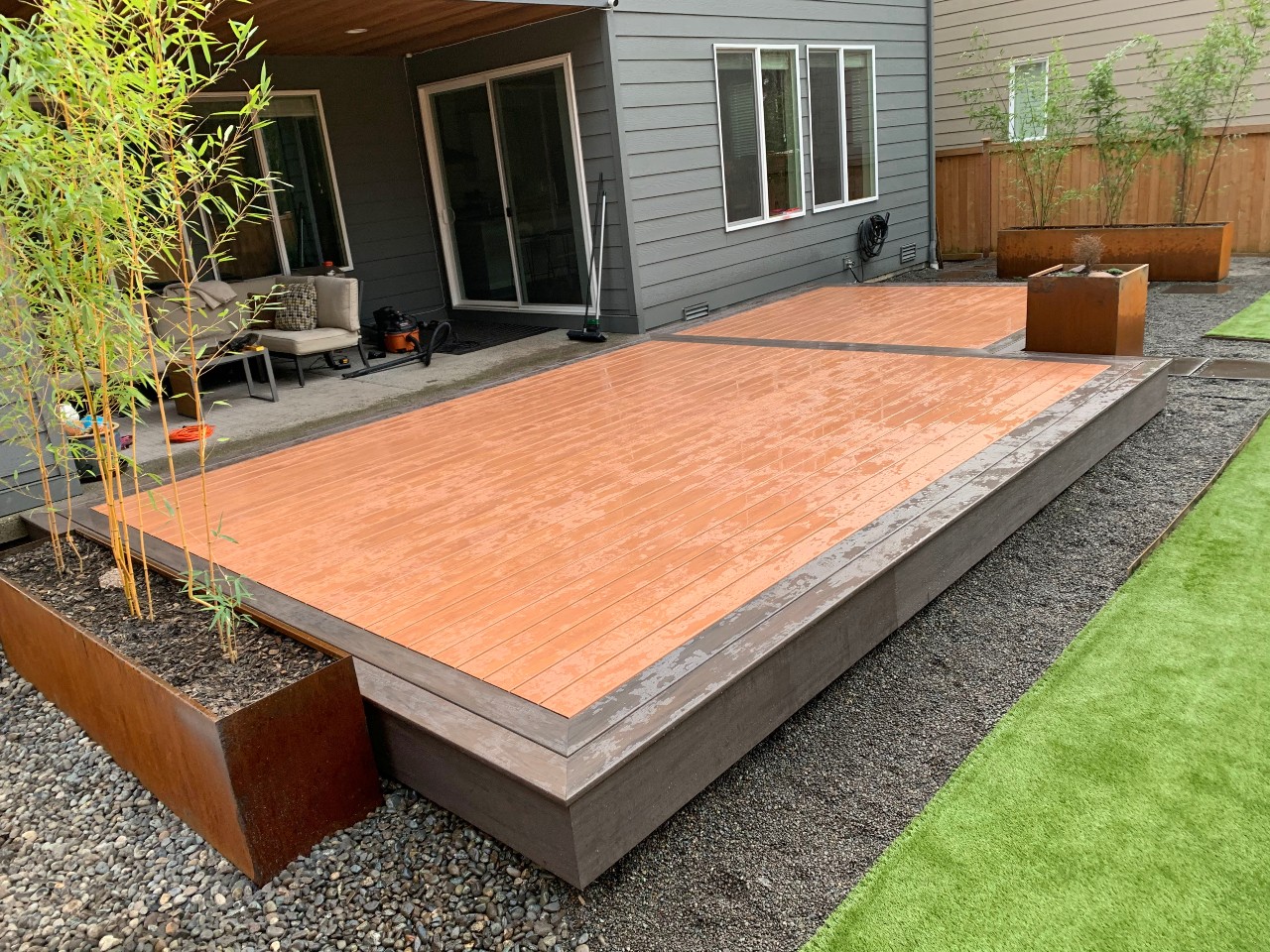 Floating composite platform deck with corten steel planters and artificial turf
