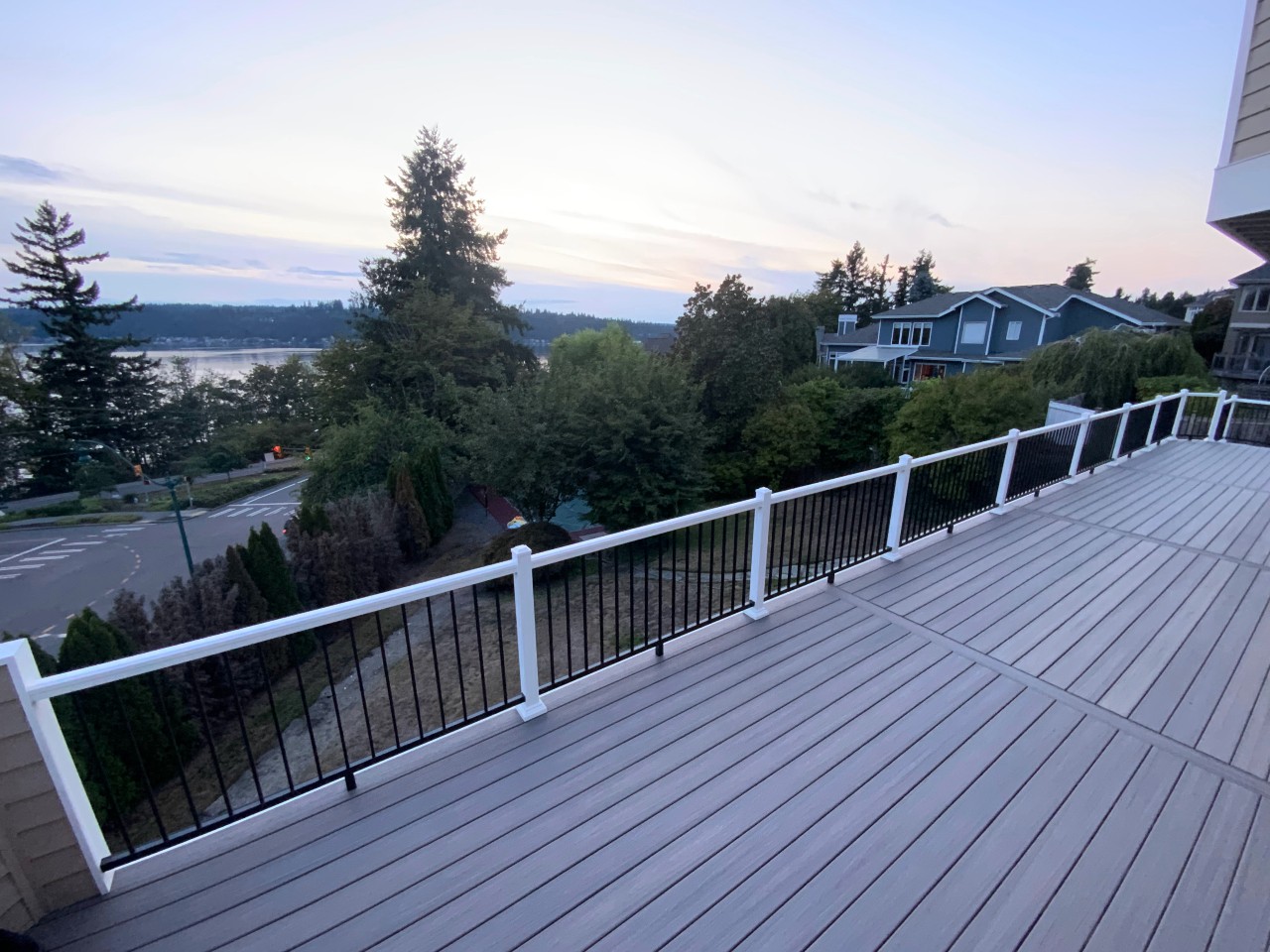 Elevated composite deck with white-post railing and a water view