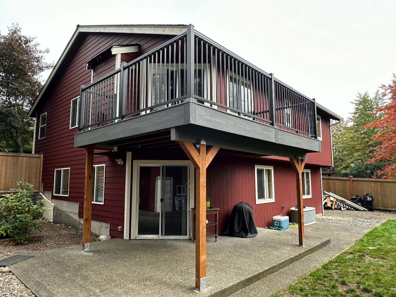 Red home with an upper composite deck on timber posts