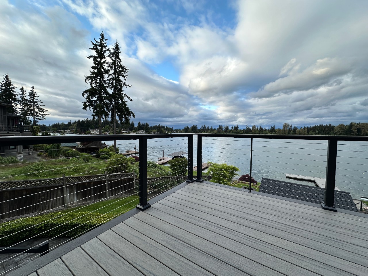 Composite deck with cable railing overlooking the lake under dramatic skies